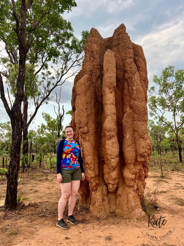 Kate standing next to a cathedral termite mound that is about 4 metres tall
