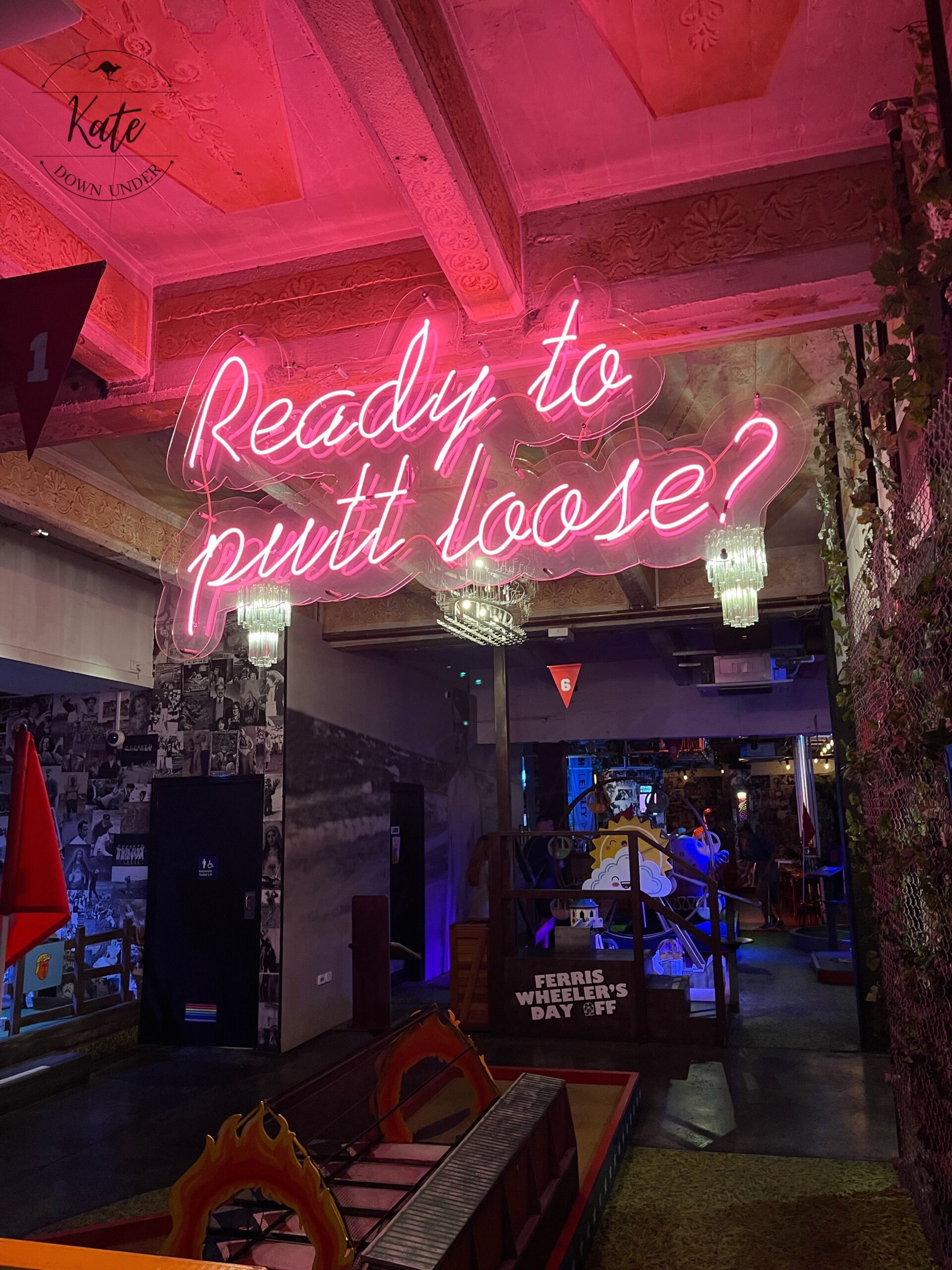 A pink neon sign that reads "ready to putt loose?"