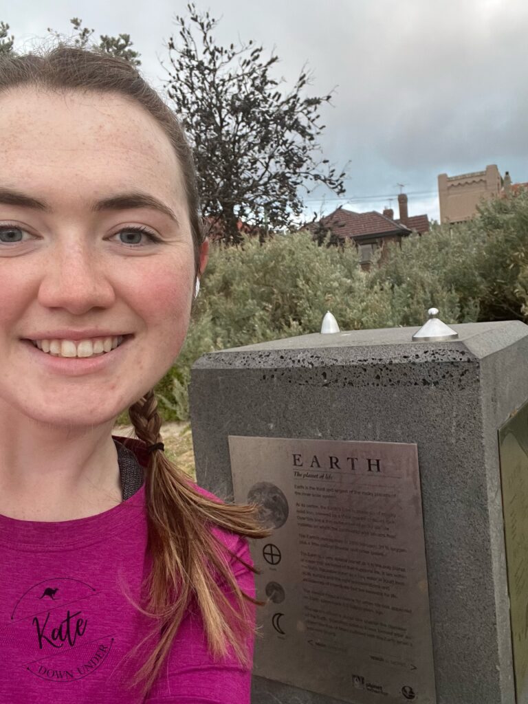 Kate taking a selfie with a model of the earth and moon at one billionth scale