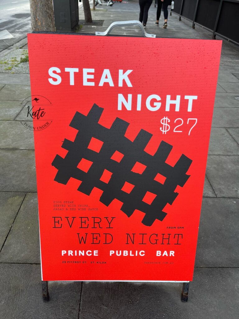 A street side sign advertising steak night, for $27 you can have a 200 g steak