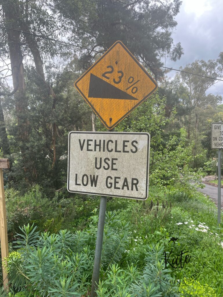 a road sign that reads 23% grade, vehicles use low gear