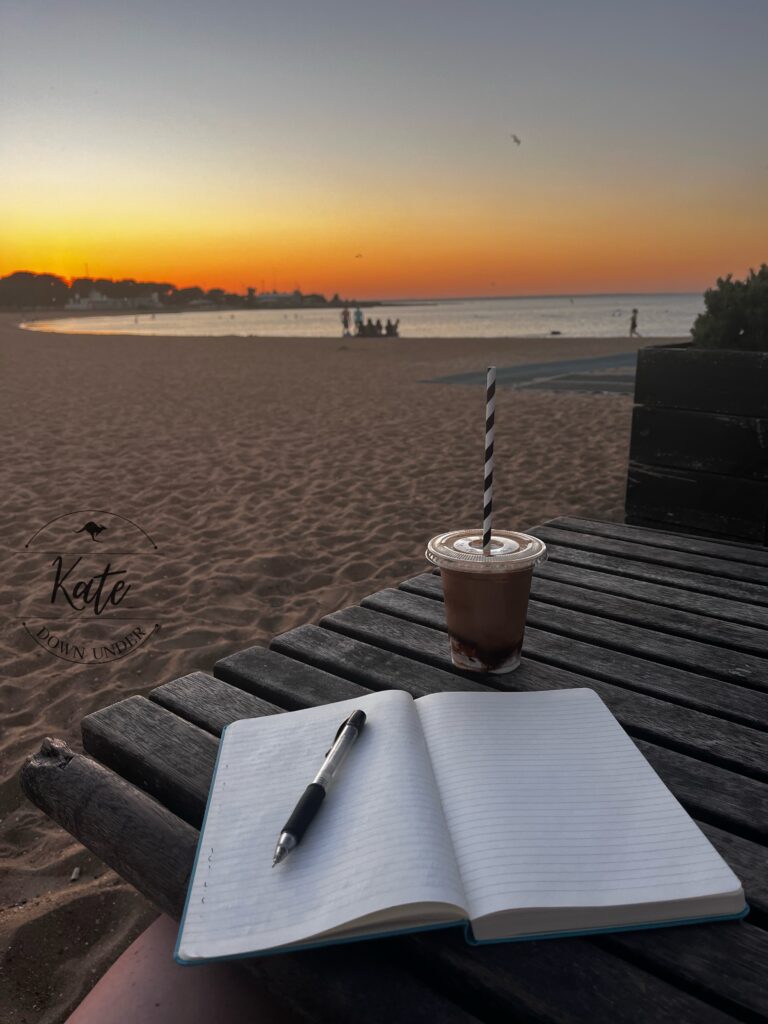 Sitting at a picnic table with my journal and an iced coffee watching the sunrise at Williamstown Beach